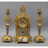 A late 19th century French three piece gilt spelter and champléve clock garniture, the eight day