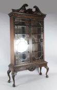 A Chippendale revival mahogany bookcase, with pierced swans neck pediment and floral carved astragal