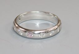 A modern 18ct white gold and gypsy set nine stone diamond ring, size N.