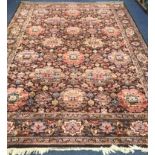 A Persian-style aubergine ground carpet, all over woven with large stylised flowerheads, 350 x 249cm