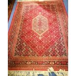 A Persian red ground rug 235cm x 170cm