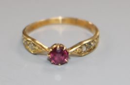 An early 20th century 18ct gold, single stone ruby ring, with diamond set shoulders, size K.