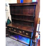 AN 19TH CENTURY AND LATER DARK OAK DRESSER the base fitted with two drawers with brass loop