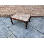 A REGENCY MAHOGANY FRAMED RECTANGULAR CAMPAIGN STYLE STOOL/LUGGAGE RACK with cane seat and raised on