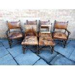A SET OF SIX DINING CHAIRS with studded leather backrests and stuff over seats to include two carver