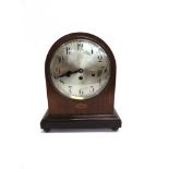 AN EDWARDIAN MANTLE CLOCK with steel dial and chimney movement and contained in an arched inlaid