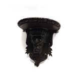 A CARVED OAK FIGURAL WALL BRACKET modelled as a Satyr, the semicircular top 38cm wide 40cm high