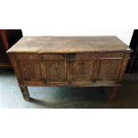 AN EARLY PANELLED AND CARVED COFFER raised on four square supports (later converted to a cupboard