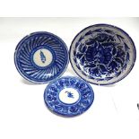 THREE TIN GLAZED EARTHENWARE PLATES the largest 25cm diameter