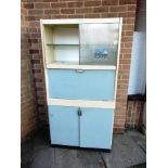 A VINTAGE KITCHEN CABINET BY EASTHAM with sliding glass doors above a fitted cupboard with drop-down