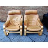 A PAIR OF BROWN LEATHER UPHOLSTERED CANTILEVER ARMCHAIRS on laminated beech bases, labels for '