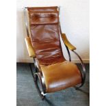A STEEL FRAMED ROCKING ARMCHAIR with leather look covered upholstery