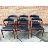 KAI KRISTIANSEN, DENMARK: a set of six teak dining chairs with black vinyl upholstered seats and