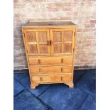A LIMED OAK TALLBOY in the manner of Heals but unmarked, with cupboard with panelled doors above