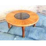 A G-PLAN CIRCULAR TEAK COFFEE TABLE with smoked glass inset circular centre, on cylindrical supports