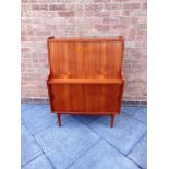 A DANISH TEAK BUREAU the fall front enclosing fitted interior with four drawers above sliding doors,