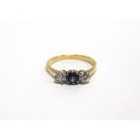 A SAPPHIRE AND DIAMOND THREE STONE RING indistinct mark, the sapphire flanked by one modern cut