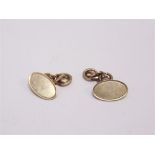 A PAIR OF 9 CARAT GOLD PAIR OF CUFFLINKS the plain oval panels with chain connection to figure of
