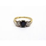 A THREE STONE SAPPHIRE AND DIAMOND RING stamped '18k', the oval cut stone flanked by brilliant cut