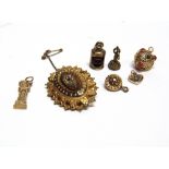 A VICTORIAN LOCKET BACK BROOCH and six charms, some gold.