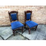 A PAIR OF CARVED OAK SIDE CHAIRS with upholstered seats and backs, on turned supports with shaped