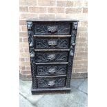 A VICTORIAN CARVED OAK WELLINGTON CHEST the five drawers with mask handles, the pilasters carved