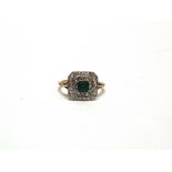 AN EMERALD AND DIAMOND CLUSTER PANEL RING stamped '18ct & Pt', the step cut measuring