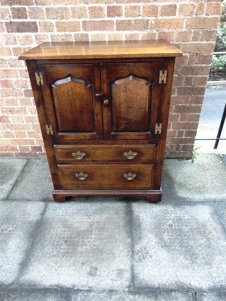 AN OAK REPRODUCTION SIDE CABINET in the manner of Tithchmarsh & Goodwin, fitted with pair of doors
