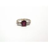 A RUBY AND DIAMOND THREE STONE RING unmarked, the oval cut stone approximately 7.6mm by 6.7mm by 3.