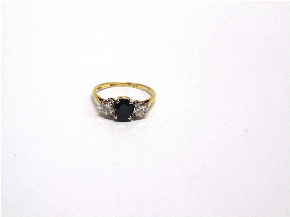 A THREE STONE SAPPHIRE AND DIAMOND RING stamped '18k', the oval cut stone flanked by brilliant cut - Image 2 of 2