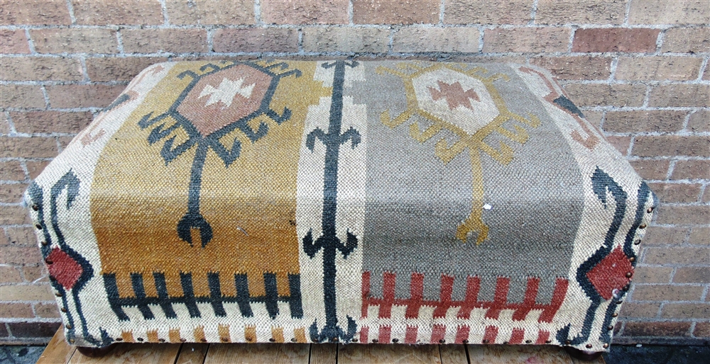 A LARGE KILIM COVERED FOOT STOOL on bun feet, 90cm x 50cm, 36cm high