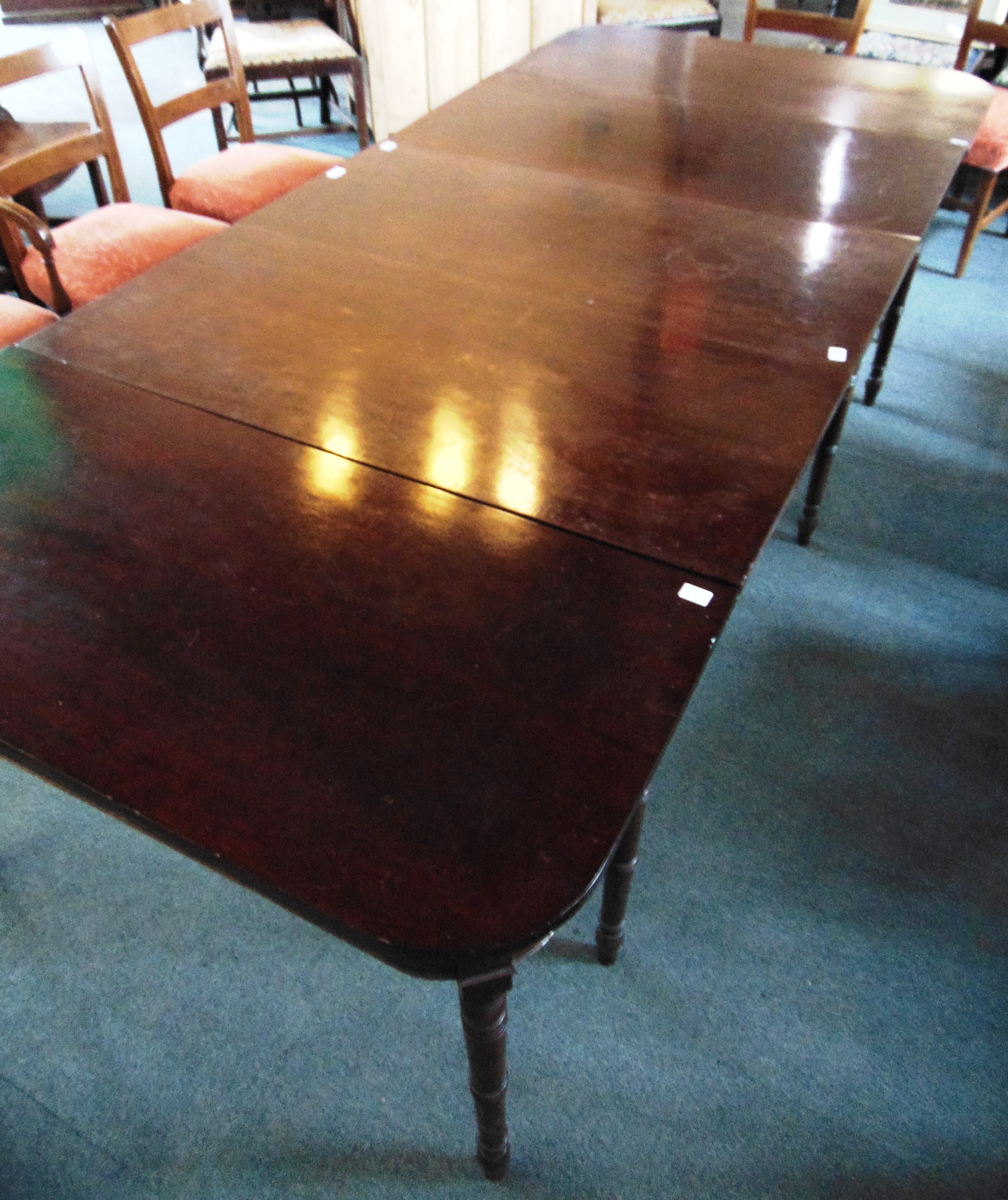 A 19TH CENTURY MAHOGANY EXTENDING DINING TABLE on ring turned supports, with central drop leaf
