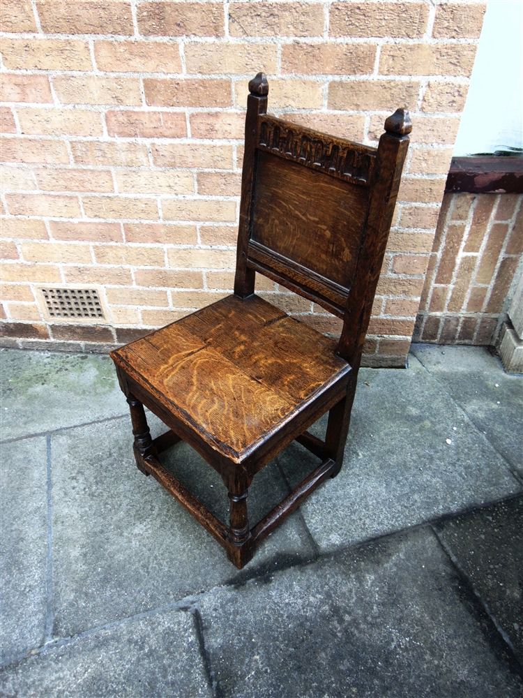 AN OAK SIDE CHAIR with carved top rail and solid seat on block turned supports