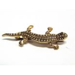 A SEED PEARL DIAMOND AND RUBY LIZARD BROOCH unmarked, pave set with pearls, central line of