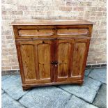 A PITCH PINE CUPBOARD with drawer above pair of panelled doors on bracket feet, 100cm wide 45cm deep