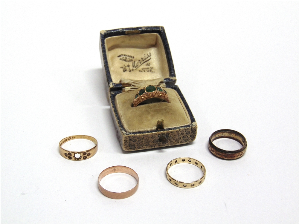 A 9 CARAT GOLD ETERNITY RING a 9 carat gold wedding ring; another, a fire stone green doublet 9