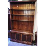 A LARGE OAK OPEN BOOKCASE fitted with four adjustable shelves above cupboard to base, 121cm wide