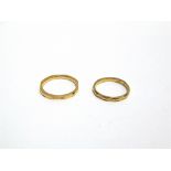 A 22 CARAT GOLD PATTERNED WEDDING RING and another similar 22 carat gold wedding ring; 5.6g gross