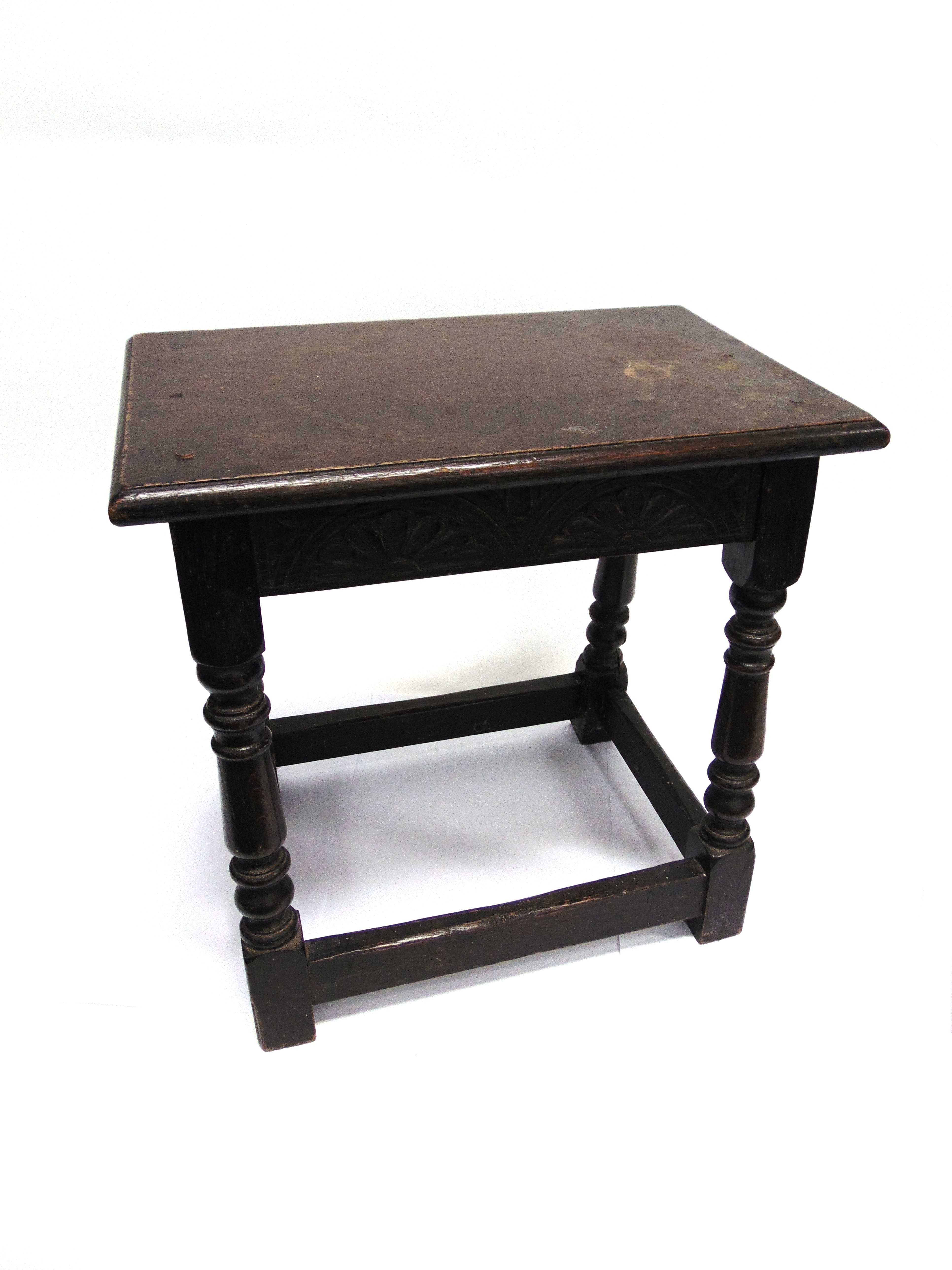 AN OAK JOINT STOOL the rectangular top 46cm x 30cm above carved frieze on turned supports with