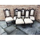 A SET OF SIX CARVED OAK DINING CHAIRS with upholstered seats and backs, on H-shape stretcher bases