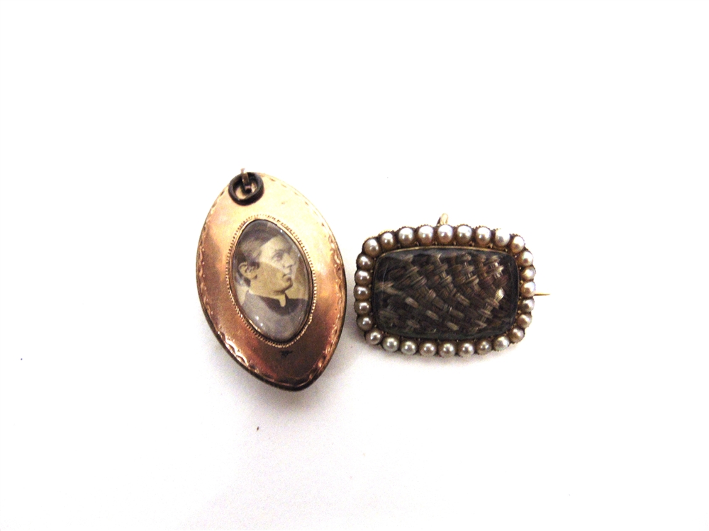 A MOURNING PENDANT with hair and seed pearls under glass, locket back now with a photograph; with