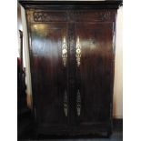 A LARGE 19TH CENTURY FRENCH CHESTNUT ARMOIRE with carved decoration, polished brass hinges and