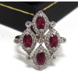 AN 18CT WHITE GOLD DRESS RING set with four oval rubies approximately 1.34ct in total and round