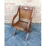 AN OAK GLASTONBURY CHAIR of typical form, with brass plaque and two pierced trefoils to the