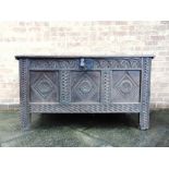 A 17TH CENTURY OAK COFFER the hinged top moulded to front and with chip carving to the sides, the