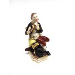 AN EARLY 19TH CENTUY DERBY FIGURE of a seated gentleman playing a flute, polychrome enamelled with