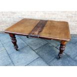 A VICTORIAN WALNUT EXTENDING DINING TABLE on fluted baluster supports with brass casters, 145cm long