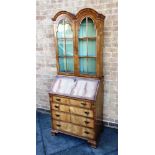 A REPRODUCTION BUREAU BOOKCASE the double arched bookcase top above bureau with fitted interior,