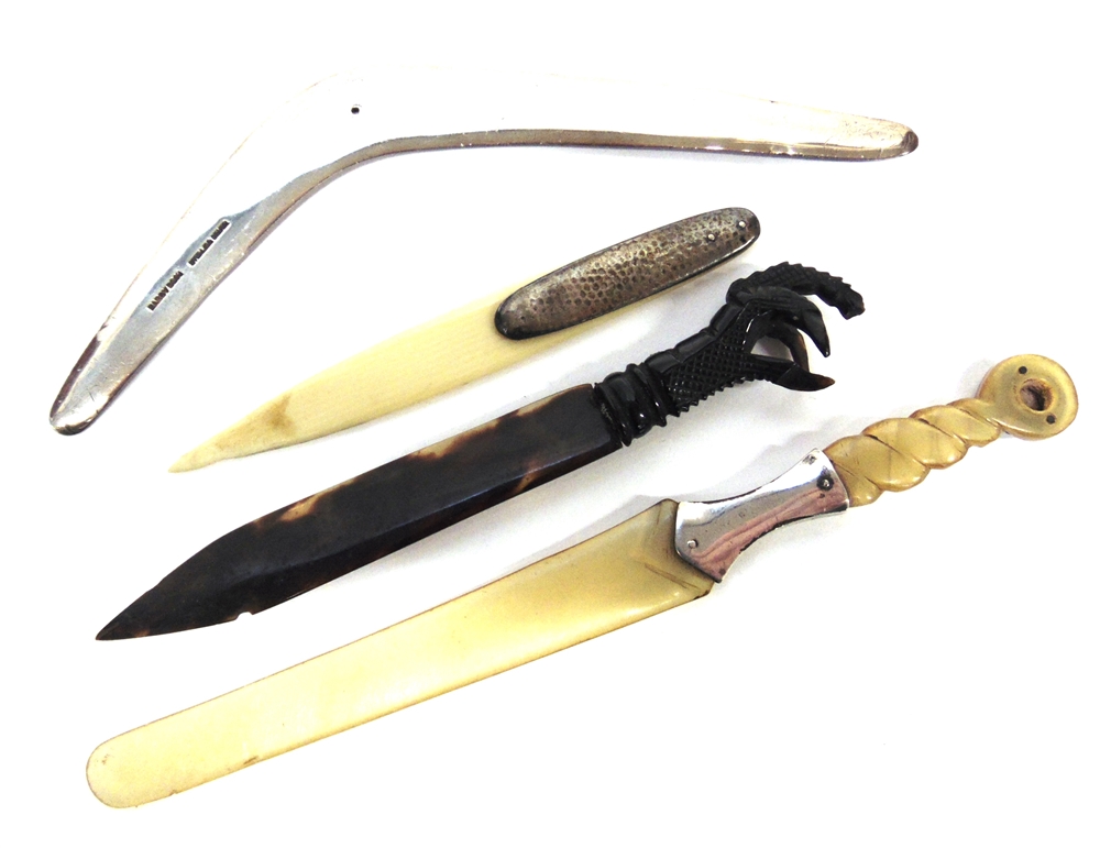 A BOOMERANG stamped 'Sterling Silver', 17cm long; a tortoiseshell paperknife with claw terminal,