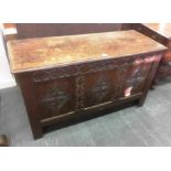 AN 18TH CENTURY OAK COFFER the triple panel front with carved decoration, 120cm wide 48cm deep